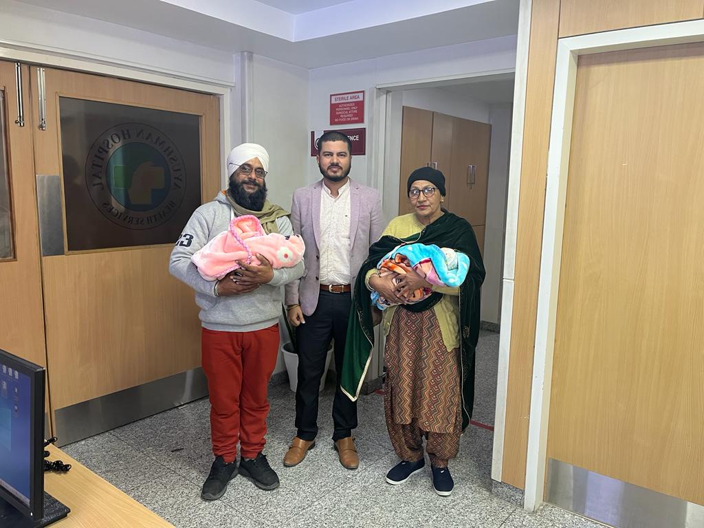 Happy family with newborn twins after surrogacy
