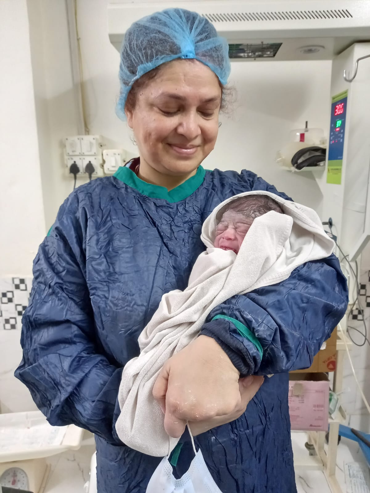 Smiling new mother with newborn baby